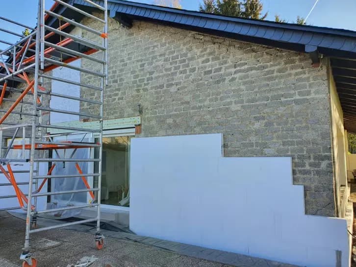 Gerenoveerde woning in Apeldoorn met nieuw stucwerk op de zijgevel en een nieuwe schuifpui